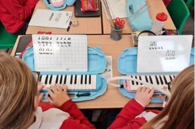 Pupils learning to play melodica.
