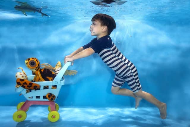 Dylan Gregory, aged four, is captured taking a shopping trip under the water. He had to take swimming lessons to meet the terms of having an underwater shoot.