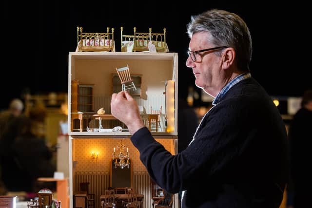 Tom Murphy, of Rugby in Warwickshire, joint owner of Present Address Miniatures setting up one of their displays of 1/12th scale Dolls House Collectables before the doors open to the public. Writer: James Hardisty