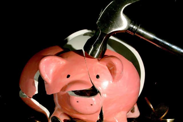 Undated file photo of a traditional piggy bank is smashed open with a hammer.