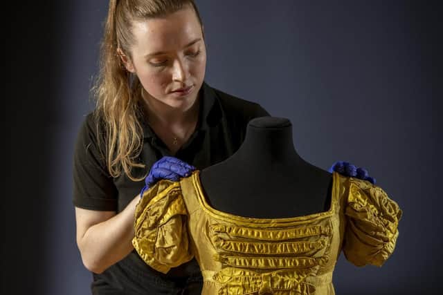This Regency dress could straight out of Bridgerton. Assistant curator Sarah Davies prepares the dress for display at Lotherton Hall. Picture by Tony Johnson.