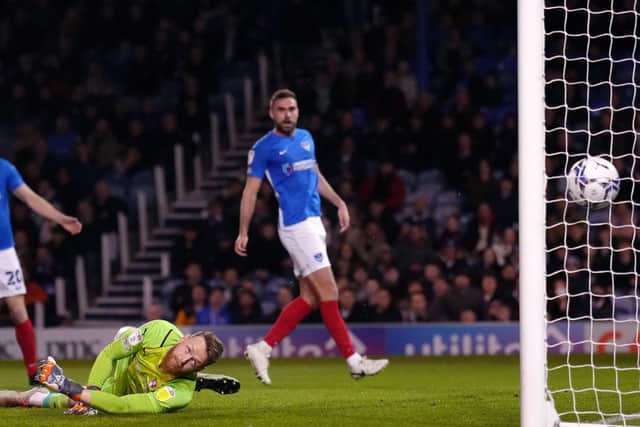 STRUGGLING: Rotherham United goalkeeper Viktor Johansson (second right) concedes the first goal from Portsmouth's Clark Robertson (right) at Fratton Park on Tuesday Picture: John Walton/PA