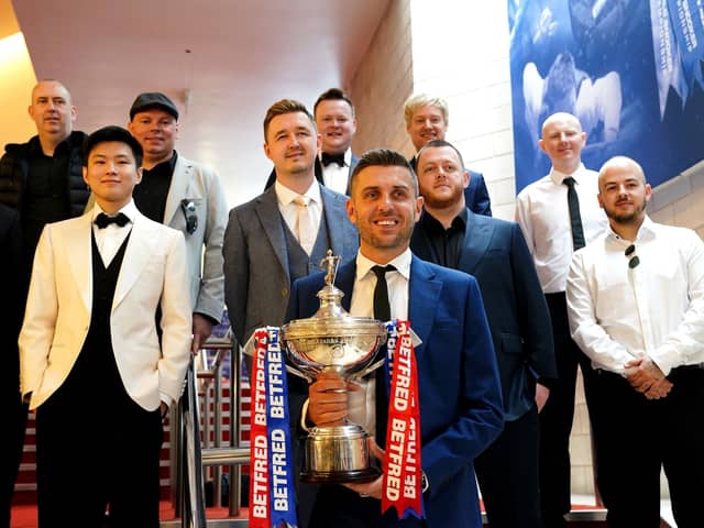 Defending champion Mark Selby (front) with the Betfred World Championship trophy with Mark Allen, Anthony McGill, Luca Brecel, Shaun Murphy, Neil Robertson, Barry Hawkins, Stuart Bingham, Yan Bingtao, Mark Williams, John Higgins, Ronnie O'Sullivan, Kyren Wilson and Zhao Xinong during the media day at the Crucible. Photo: Zac Goodwin/PA Wire.