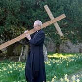 The Archbishop of Canterbury Justin Welby carries a wooden cross during the Walk of Witness at St Mary's Church, Sellindge, Kent, as he carries out his Holy Week engagements.