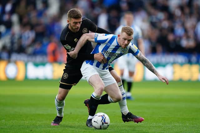 Queens Park Rangers' Sam Field and Huddersfield Town's Lewis O'Brien (right) battle for the ball.