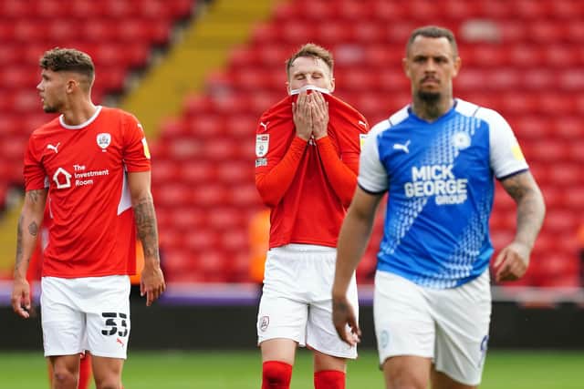 Cauley Woodrow (centre) and his Barnsley team-mates show their despondency after losing to Peterborough United at Oakwell Picture: Martin Rickett/PA