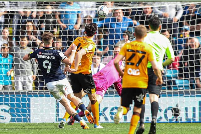 Millwall's Tom Bradshaw scores his side's second goal against Hull Cityat The Den. Picture: Kieran Cleeves/PA