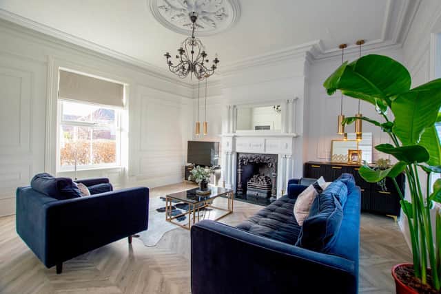 The sitting room with a panelled effect using dowling on the walls and an Ikea unit made glamorous