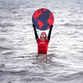 Susie Gray, from the Edinburgh Science Festival team, stands in the Firth of Forth at Portobello in Edinburgh, holding a giant black and red Earth to highlight the climate emergency and rising sea levels ahead of Earth Day on Friday April 22, 2022. Picture date: Thursday April 21, 2022. PA Photo. Photo credit: Jane Barlow/PA Wire