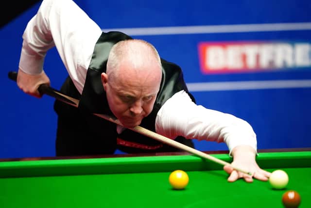 Scotland's John Higgins in action against Thailand's Noppon Saengkham at the Betfred World Championship. Photo: Zac Goodwin/PA .