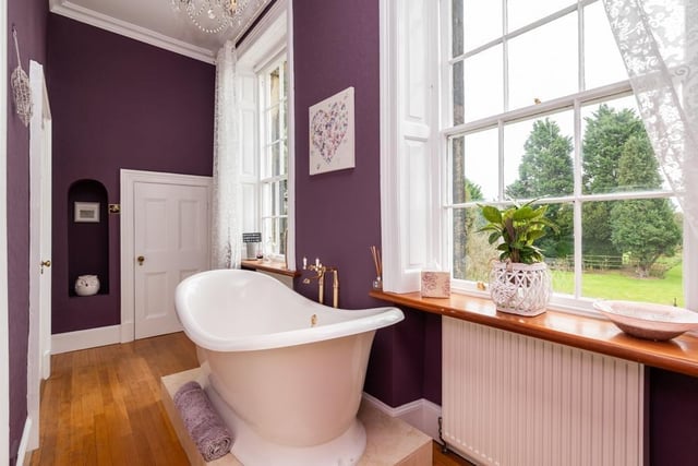 An en-suite with a Victoria and Albert free-standing, roll top bath with views over the garden