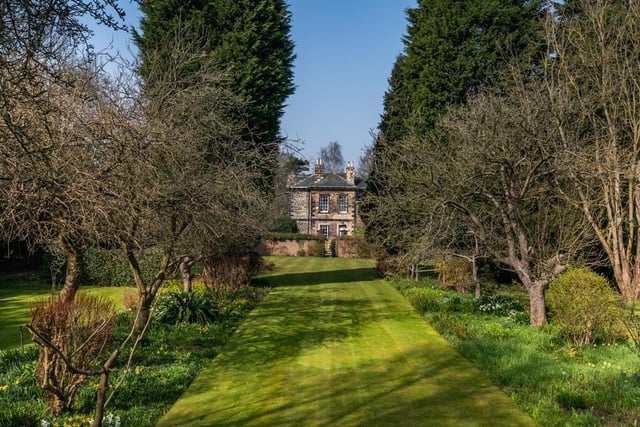 The property as an enclosed garden set within a predominantly walled boundary, extending to approximately one acre. The mature trees provide a high degree of privacy.