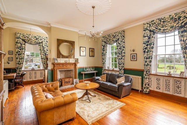 The spacious sitting room has an Adam style fireplace and original timber flooring, along with views from three Georgian windows