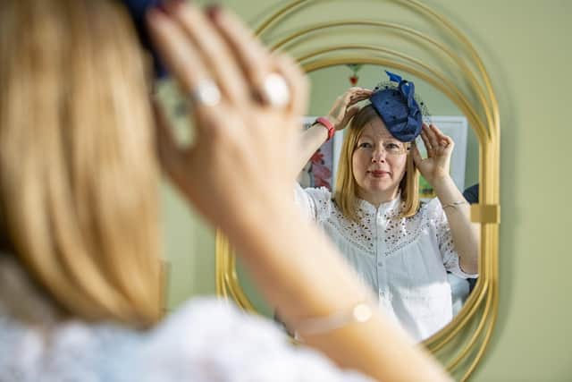 Milliner Alison Turton tries on a hat in her studio. Picture: Tony Johnson
