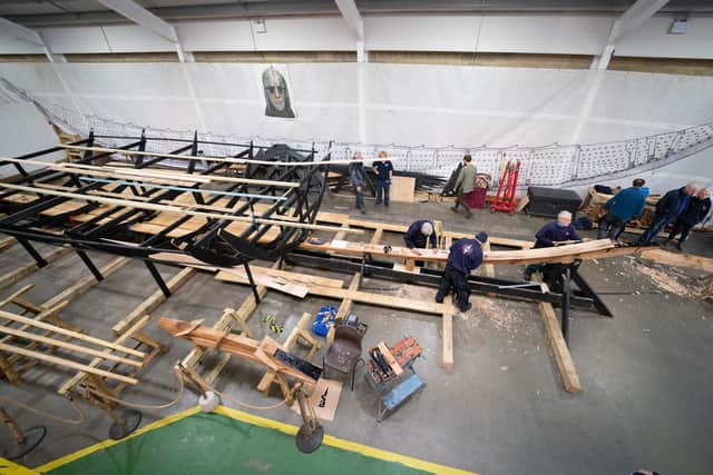 A team of volunteers work on the keel of the 88ft-long replica of the Sutton Hoo longship. Byline: Joe Giddens/PA Wire