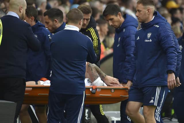 Leeds United's Stuart Dallas is stretchered off after picking an injury during the English Premier League soccer match between Leeds United and Manchester City at Elland Road  (AP Photo/Rui Vieira)