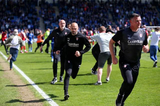 INVASION: Paul Warne (centre) and assistant Richie Barker run down the tunnel as Rotherham United fans come onto the Priestfield Stadium pitch