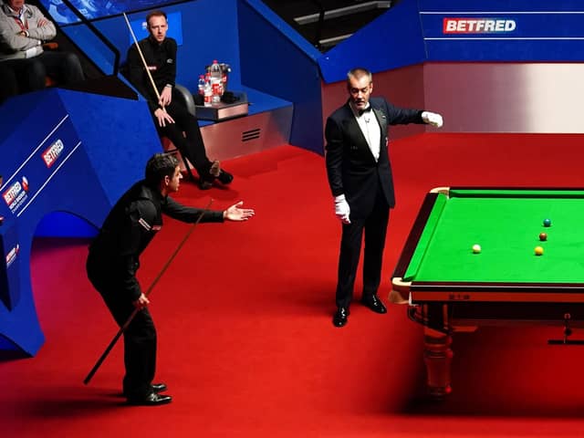 Ronnie O'Sullivan makes his point to the referee, as Judd Trump looks on. Picture: PA.