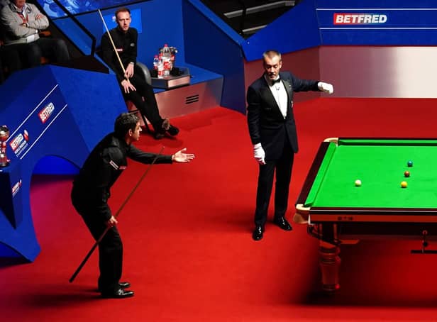 Ronnie O'Sullivan makes his point to the referee, as Judd Trump looks on. Picture: PA.