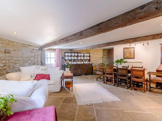 The formal dining room has a sitting area with exposed beams