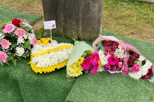 New flowers which had been placed on the grave after a woman was laid to rest again in a ceremony today (Friday). The grave was disturbed at a cemetery in Barnsley earlier this month.