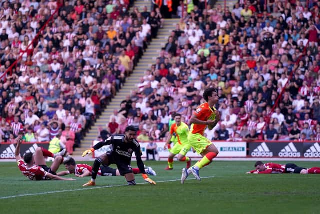 TRAIL OF DISASTER: Three Sheffield United players lie on the ground after Nottingham Forest's Brennan Johnson celebrates scoring his side's second goal of the game at Bramall Lane, Sheffield. Picture: Tim Goode/PA