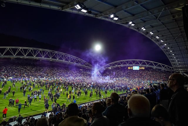 Huddersfield fans rush onto the field to celebrate with the Town players.
