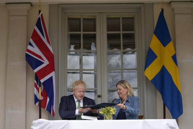 Boris Johnson, left, and Sweden's Prime Minister Magdalena Andersson exchange files as they sign a security assurance. Photo by Frank Augstein - WPA Pool/Getty Images.