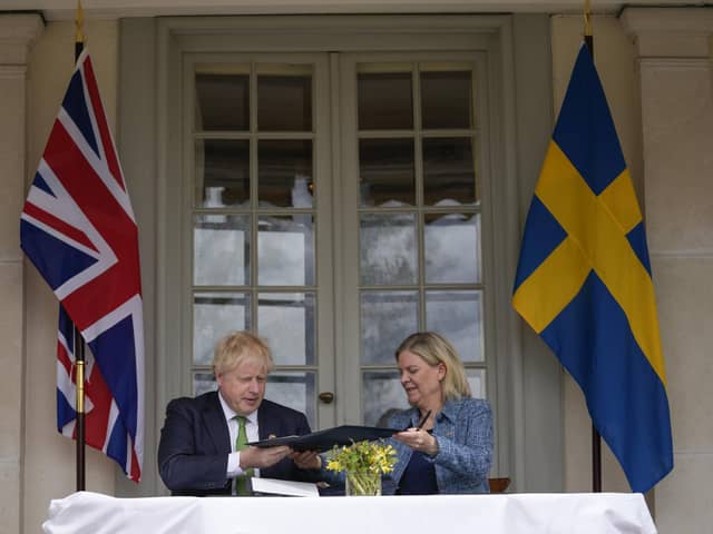 Boris Johnson, left, and Sweden's Prime Minister Magdalena Andersson exchange files as they sign a security assurance. Photo by Frank Augstein - WPA Pool/Getty Images.