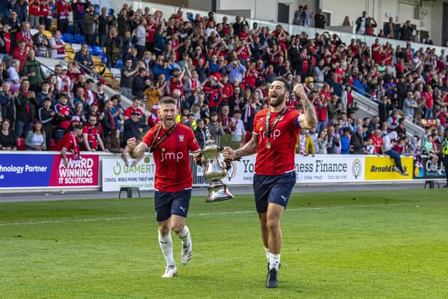 York City captain Paddy McLaughlin and Matty Brown with the trophy celebrating promotion to the National League.   Picture: Tony Johnson