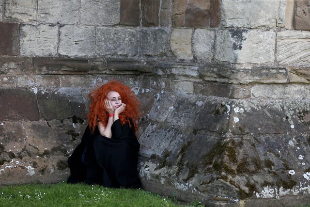 One vampire adopts a striking pose by the Abbey walls