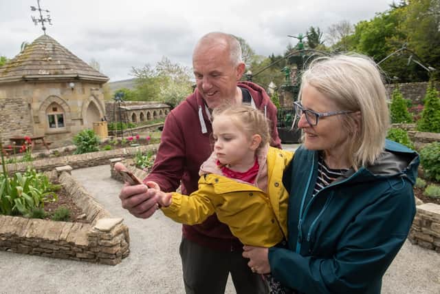 Roy and Cassandra Kitchin, from Morecambe, with their granddaughter, Angelica
Walker, using the new app at The Forbidden Corner.