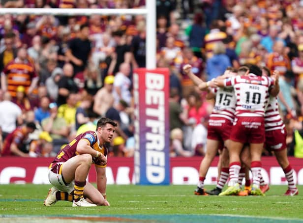 Huddersfield Giants' Joe Greenwood reacts to his team's Challenge Cup Final defeat as Wigan Warriors player celebrate at the Tottenham Hotspur Stadium Picture: Mike Egerton/PA