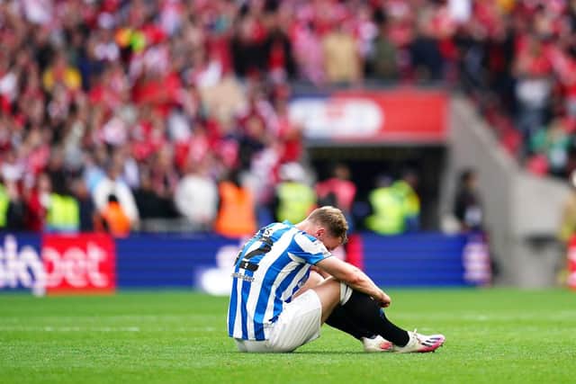 A disconsolate Tom Lees on the pitch after the final whistle after a shattering result for Huddersfield Town. Picture: PA.