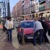 The Full Monty charity night lads attempting to bump an abandoned car out of the way of a Supertram on West Street, Sheffield
