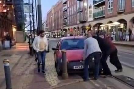 The Full Monty charity night lads attempting to bump an abandoned car out of the way of a Supertram on West Street, Sheffield