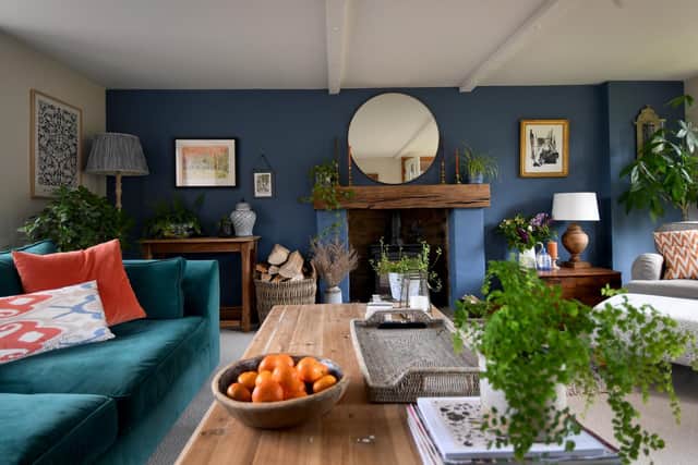 The living room at Heron Barn, the home they bought five years ago, near Sowerby Bridge. The fireplace wall is painted in a rich but homely blue. Becca collects prints from street artists on holiday.