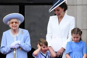 Catherine, Duchess of Cambridge, reacts as Prince Louis of Cambridge covers his ears, as they stand with Queen Elizabeth II and Princess Charlotte of Cambridge to watch a special flypast from the Buckingham Palace balcony.