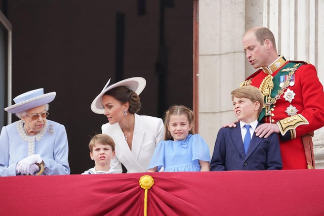 Queen Elizabeth II stands with from left, Prince Louis of Cambridge, Catherine, Duchess of Cambridge, Princess Charlotte of Cambridge, Prince George of Cambridge and Prince William, Duke of Cambridge, to watch a special flypast from the Buckingham Palace balcony.