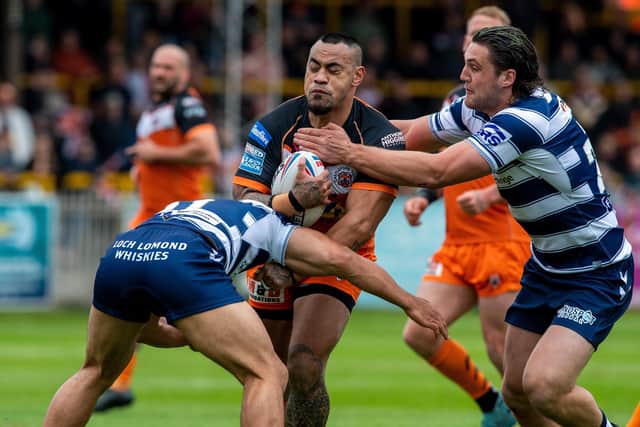 Mahe Fonua is held by Willis Isa and Jai Field during 
Castleford Tigers v Wigan Warriors in Betfred SuperLeague. (Picture: Bruce Rollinson)