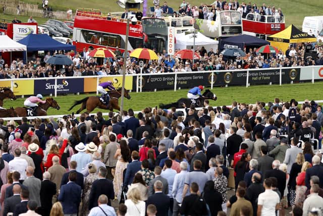 Racegoers watch as Tees Spirit ridden by jockey Barry McHugh win the Simpex Express 'Dash' Handicap on Derby Day (Picture: PA)