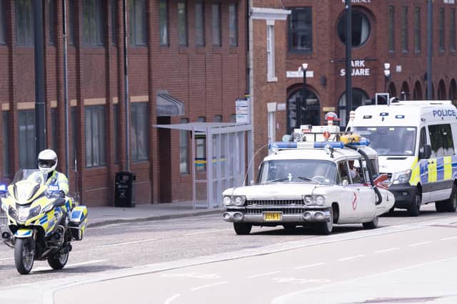 Police escort the Ghostbusters vehicle, 'ECTO-1'