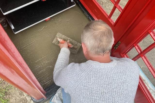 Laying a new floor within the phone box museum. Photo courtesy of Paul Garbutt