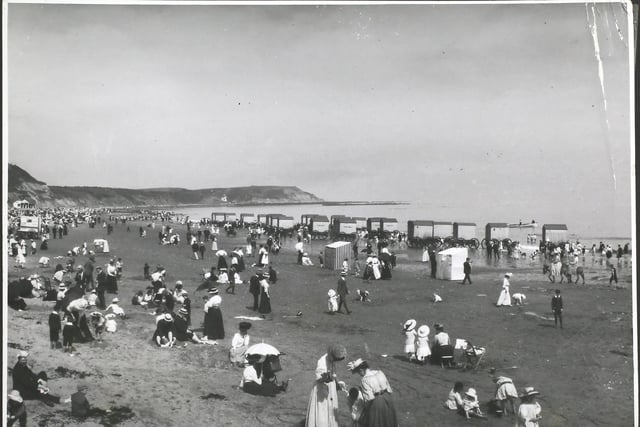 Crowds on the beach at Scarborough, North Yorkshire, with a row of bathing machines at the water's edge (Photo by Hulton Archive/Getty Images)