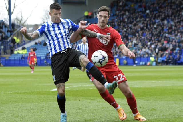 Defender Ben Heneghan, in action for Wimbledon last season against Sheffield Wednesday’s Marvin Johnson, will be an Owls player next season. Picture: Steve Ellis