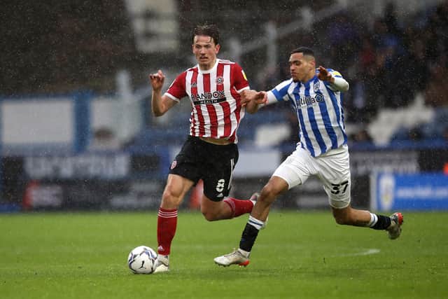 Sheffield United's Sander Berge (left) and Huddersfield Town's Jon Russell battle for the ball. Picture: PA