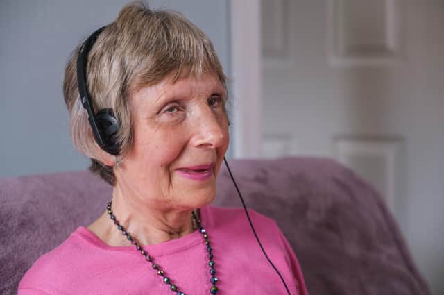 A woman with deafblindness takes a call. Image supplied by Deafblind UK.