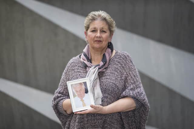 Karen Wilson holds a photograph of her late husband Julian Wilson, a former sub-postmaster, after giving evidence at the International Dispute Resolution Centre in London for the Post Office Horizon IT inquiry.