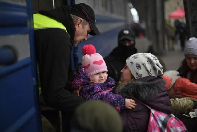 A baby cries as a train prepares to depart from a station in Lviv, western Ukraine, enroute to Poland, on March 3, 2022. - Russian forces have taken over the Ukrainian city of Kherson, local officials confirmed March 2, 2022 the first major urban centre to fall since Moscow invaded a week ago. Photo by DANIEL LEAL/AFP via Getty Images.
