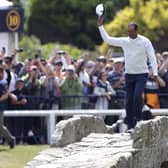 USA's Tiger Woods waves to the crowd as he goes over the Swilcan Bridge on the 18th. Picture: PA